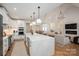 Open-concept living space boasts vaulted ceilings, a fireplace, and seamless flow to the kitchen at 115 Woodward Way, Iron Station, NC 28080