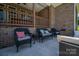 Relaxing outdoor patio featuring comfortable seating arrangements and a serene atmosphere with brick columns and stairs at 115 Woodward Way, Iron Station, NC 28080