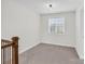 Cozy bedroom with natural light, carpet, and adjacent hallway with railing at 13332 Caite Ridge Rd, Davidson, NC 28036