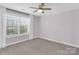 Sunlit bedroom boasts a ceiling fan, neutral paint, and a large window with blinds at 13332 Caite Ridge Rd, Davidson, NC 28036