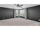 Neutral bedroom featuring dark gray walls, multiple windows and ceiling fan at 13332 Caite Ridge Rd, Davidson, NC 28036