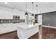 Beautiful white kitchen island features pendant lights, stainless appliances, and hardwood floors at 13332 Caite Ridge Rd, Davidson, NC 28036