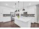Bright kitchen features stainless steel appliances, white cabinetry, a center island, and stylish pendant lighting at 13332 Caite Ridge Rd, Davidson, NC 28036