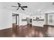 Open-concept living space with kitchen island, fireplace, dark hardwood floors, and ceiling fan at 13332 Caite Ridge Rd, Davidson, NC 28036
