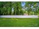 A white vinyl privacy fence encloses a large, grassy backyard surrounded by mature trees at 137 Burton Hills Cir, Gastonia, NC 28054
