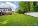A well-maintained backyard features a large lawn, mature trees, and a white privacy fence at 137 Burton Hills Cir, Gastonia, NC 28054