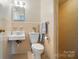 Bathroom with unique wall tiling, pedestal sink and a glass door shower at 137 Burton Hills Cir, Gastonia, NC 28054