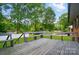 A spacious wooden deck with built-in benches overlooks a lush green yard and mature trees at 137 Burton Hills Cir, Gastonia, NC 28054
