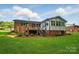 The brick home features a wooden deck, a sunroom addition, and well-manicured landscaping at 137 Burton Hills Cir, Gastonia, NC 28054