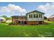 The well-kept home features a deck, a sunroom addition, and a sprawling green lawn at 137 Burton Hills Cir, Gastonia, NC 28054