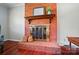 Close-up of brick fireplace with wooden mantel, decorative accents, and hardwood floors at 137 Burton Hills Cir, Gastonia, NC 28054