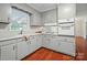 Bright kitchen featuring gray cabinets, modern appliances, and beautiful hardwood floors at 137 Burton Hills Cir, Gastonia, NC 28054