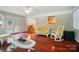 Sunroom showcasing hardwood floors, white wicker furniture and a lovely view through French doors at 137 Burton Hills Cir, Gastonia, NC 28054