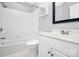 Clean, all-white bathroom with tiled walls, shower, bathtub, toilet, and vanity, creating a fresh look at 13932 Queens Harbor Rd, Charlotte, NC 28278