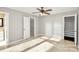 Sun-drenched bedroom with tile flooring, a ceiling fan, and multiple doorways offering versatile access at 13932 Queens Harbor Rd, Charlotte, NC 28278