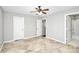 Bright bedroom featuring tile flooring, a ceiling fan, and multiple doorways enhancing accessibility at 13932 Queens Harbor Rd, Charlotte, NC 28278