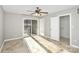 Light-filled bedroom with neutral tones, tile flooring, a ceiling fan and a private exterior patio at 13932 Queens Harbor Rd, Charlotte, NC 28278