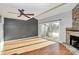 Charming living room featuring a stone fireplace, hardwood floors and ceiling fan at 13932 Queens Harbor Rd, Charlotte, NC 28278
