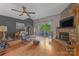 Cozy living room with stone fireplace, wood floors, and vaulted ceiling at 13932 Queens Harbor Rd, Charlotte, NC 28278