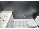 Modern powder room with white vanity, toilet, and dark gray accent wall at 13932 Queens Harbor Rd, Charlotte, NC 28278