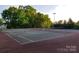 Outdoor tennis courts surrounded by mature trees offer residents a place to play for exercise and enjoyment at 13932 Queens Harbor Rd, Charlotte, NC 28278