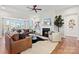 Bright living room featuring hardwood floors, leather couches, fireplace and a large window with a view at 149 Glenn Dr, Mooresville, NC 28115
