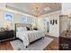 Well-appointed bedroom with tray ceiling, modern chandelier, and a view to the ensuite bath at 149 Glenn Dr, Mooresville, NC 28115