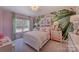 Bright bedroom featuring light pink walls with nature inspired wallpaper, a window view and matching white furnishings at 153 Glenn Dr, Mooresville, NC 28115