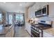 Well-equipped kitchen features stainless steel appliances, granite countertops, subway tile backsplash, and open dining area at 153 Glenn Dr, Mooresville, NC 28115
