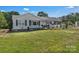 Inviting single-story house with traditional siding, dark shutters, manicured lawn and an adjacent carport at 159 Old Home Pl, China Grove, NC 28023