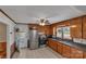 This kitchen has wood cabinets, stainless steel appliances and tiled floor, and a door to the back yard at 159 Old Home Pl, China Grove, NC 28023