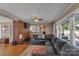 A living room with wood floors, a brick wall, and access to the kitchen and backyard at 159 Old Home Pl, China Grove, NC 28023