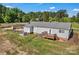 Backyard view featuring a deck with stairs, patio with chairs, and a well-maintained lawn at 159 Old Home Pl, China Grove, NC 28023