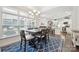 Open-concept dining area with dark wood table, kitchen view, and lots of natural light at 16112 Lakeside Loop Ln, Cornelius, NC 28031