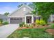 Charming home featuring manicured lawn, stone accents, attached two-car garage and covered front entryway at 16112 Lakeside Loop Ln, Cornelius, NC 28031