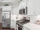 Modern kitchen features stainless steel appliances, white cabinetry, and stone countertops at 16112 Lakeside Loop Ln, Cornelius, NC 28031