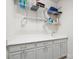 Laundry room featuring white cabinets with a sink, and overhead shelving for optimal storage at 16112 Lakeside Loop Ln, Cornelius, NC 28031