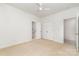 Bright bedroom featuring neutral carpet, ceiling fan, closet, and doorway leading to the bathroom at 1654 Scotch Pine Ln, Fort Mill, SC 29708