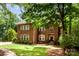 Beautiful two-story brick home with a well-manicured lawn and mature trees at 1654 Scotch Pine Ln, Fort Mill, SC 29708