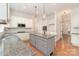 Kitchen featuring stainless steel appliances, a gray island with granite countertops, and white shaker cabinets at 1654 Scotch Pine Ln, Fort Mill, SC 29708