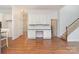 Bright room featuring hardwood floors, a staircase, and custom built-in cabinets with granite countertops at 1654 Scotch Pine Ln, Fort Mill, SC 29708