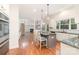 Open kitchen with stainless steel appliances, a gray island with granite countertops, and hardwood floors at 1654 Scotch Pine Ln, Fort Mill, SC 29708