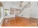 Spacious living room featuring hardwood floors, bright windows, and a staircase leading to the upper level at 1654 Scotch Pine Ln, Fort Mill, SC 29708