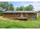 Brick house exterior featuring a wooden deck with wheelchair access, a modest backyard, and a classic design at 205 Pinehurst Dr, Kings Mountain, NC 28086