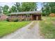 Charming brick home with covered front porch, and a gravel driveway at 205 Pinehurst Dr, Kings Mountain, NC 28086
