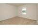 Bright bedroom features neutral carpet, a window letting in natural light, and fresh paint throughout at 2210 Transatlantic Ave, Charlotte, NC 28215