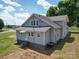 This is a view of the back of the light gray home on a beautiful sunny day at 225 N Main St, Mount Pleasant, NC 28124