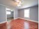 Bedroom with natural light from a window, wood flooring, and neutral painted walls at 225 N Main St, Mount Pleasant, NC 28124