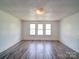 Bright bedroom featuring updated flooring, fresh paint, and three large windows at 225 N Main St, Mount Pleasant, NC 28124