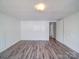 Bright bedroom showcasing modern floors, fresh paint, and entry to an adjoining space at 225 N Main St, Mount Pleasant, NC 28124
